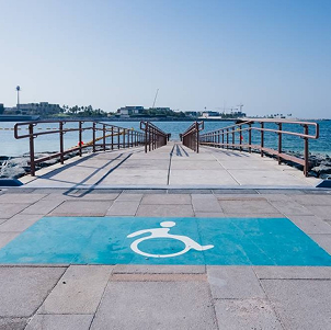 Accessible ramp leading to the sea with a wheelchair symbol painted on the ground